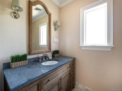 a bathroom with a granite countertop sink and a mirror