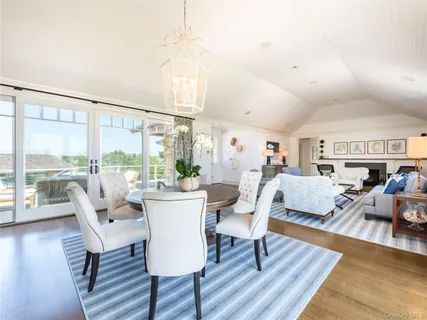 a living room with furniture large window and wooden floor