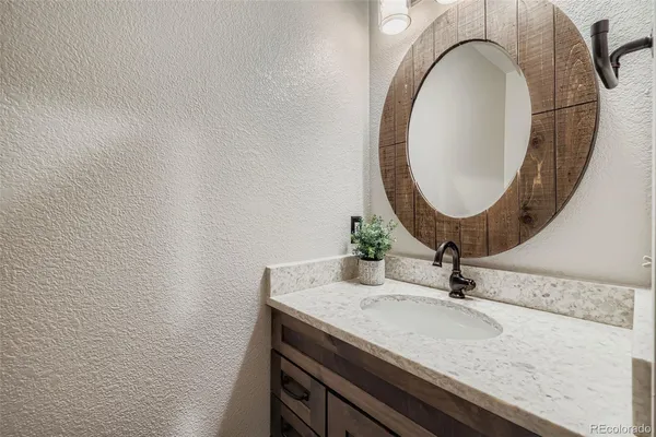 a bathroom with a granite countertop sink and a mirror
