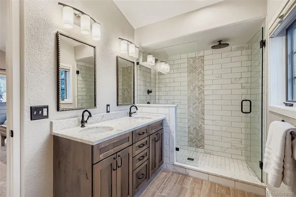 a bathroom with a double vanity sink mirror and shower