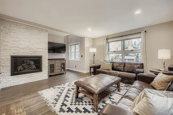 a living room with furniture a fireplace and a flat screen tv