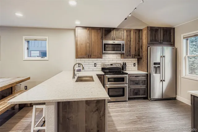 a kitchen with stainless steel appliances a stove microwave and refrigerator