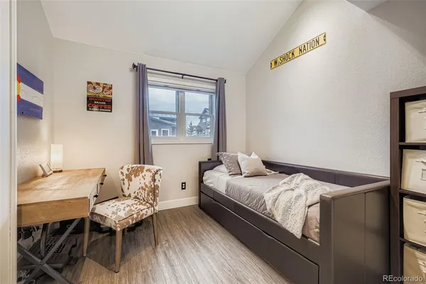 a bedroom with a bed and wooden floor