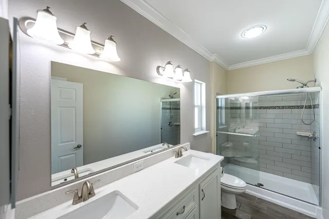 a bathroom with a sink a toilet and shower