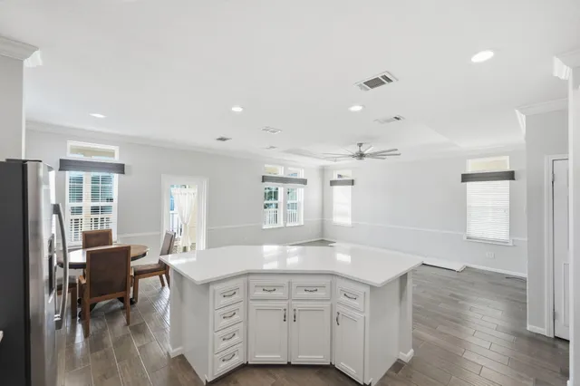 a view with granite countertop kitchen island a sink dishwasher a dining table and chairs with wooden floor