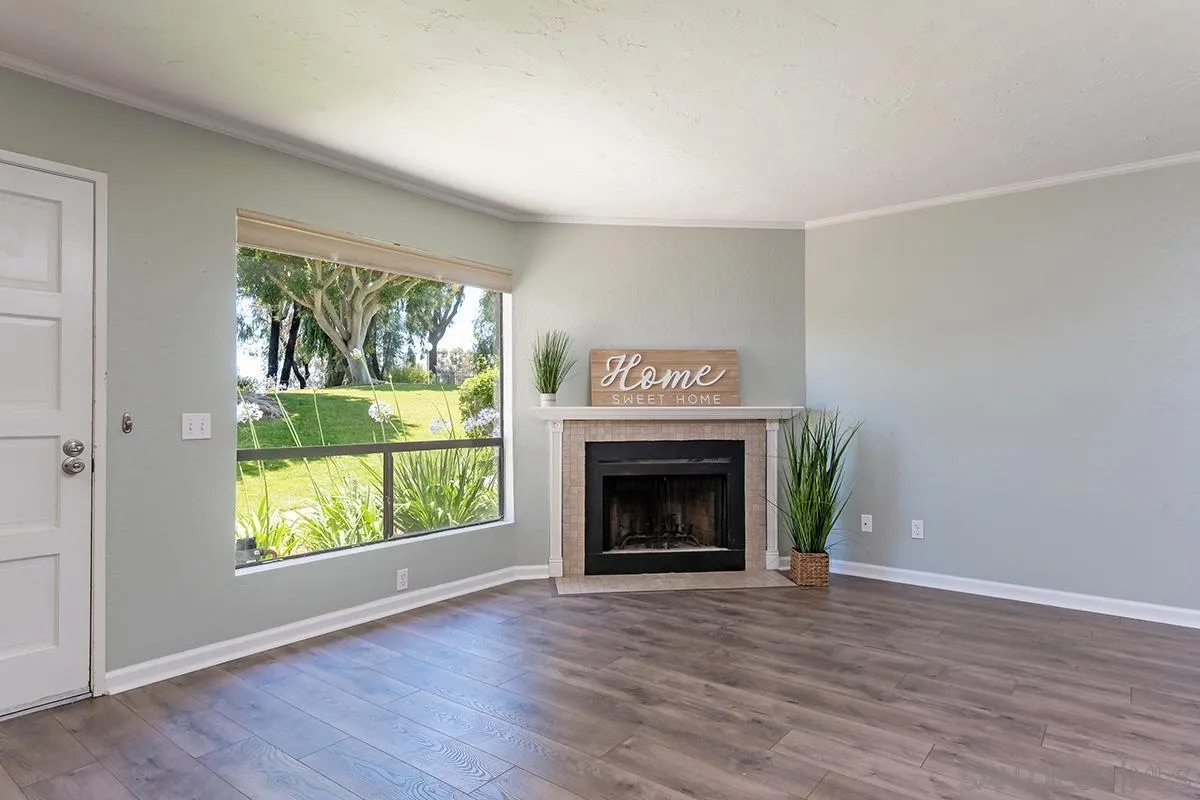 705 Copper Drive Vista, CA 92083 - Photo 12 of 31 a view of an empty room with wooden floor fireplace and a window