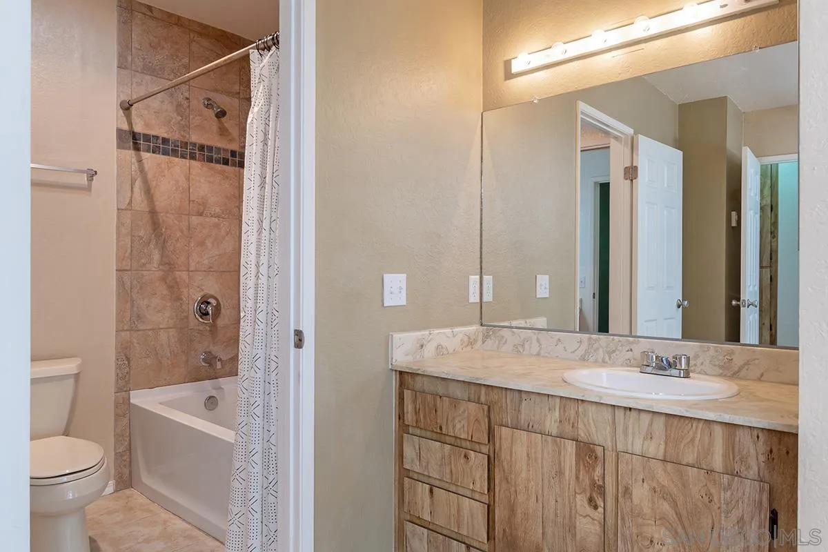 705 Copper Drive Vista, CA 92083 - Photo 18 of 31 a bathroom with a granite countertop sink a toilet and shower