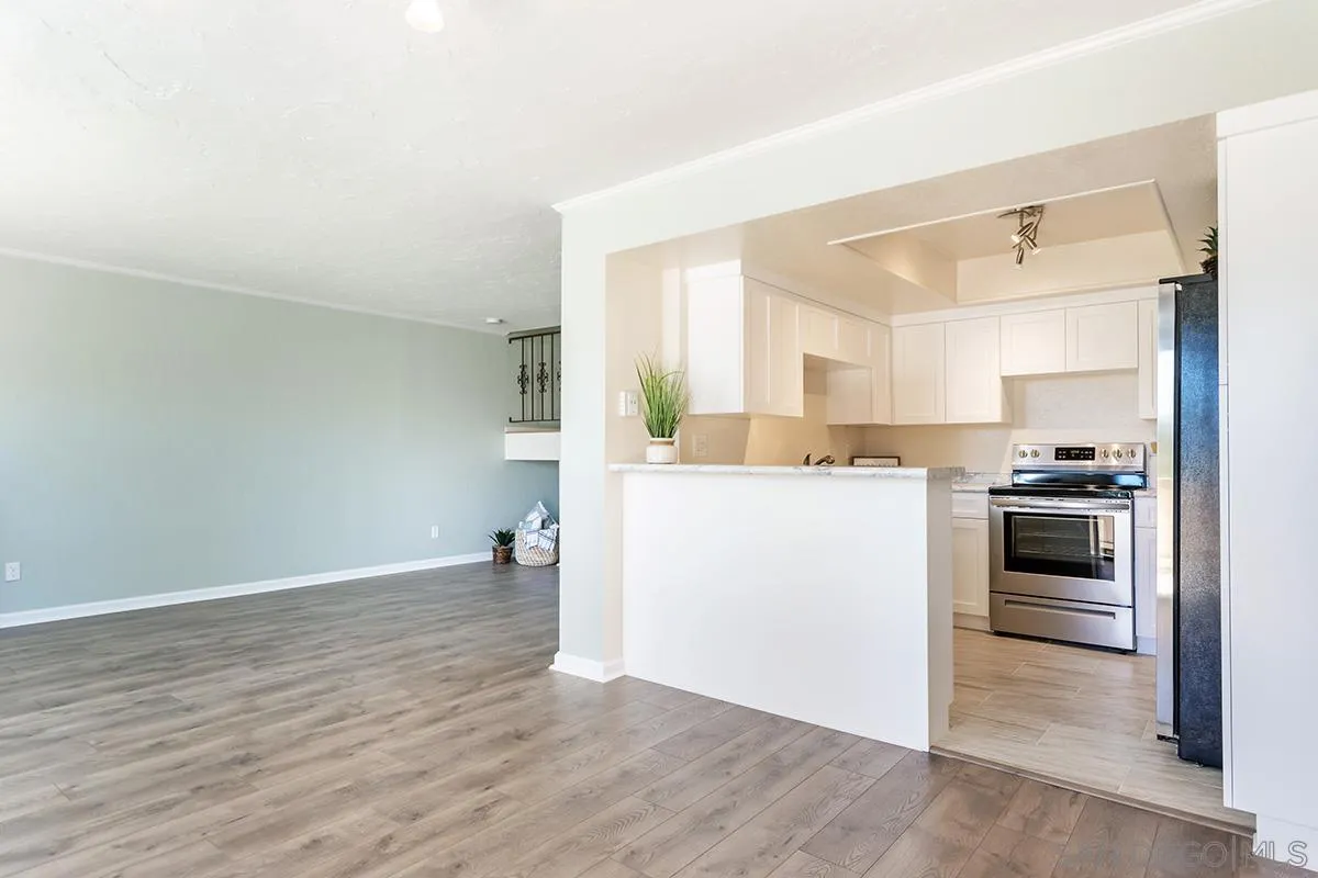 705 Copper Drive Vista, CA 92083 - Photo 5 of 31 a kitchen with a refrigerator and white cabinets