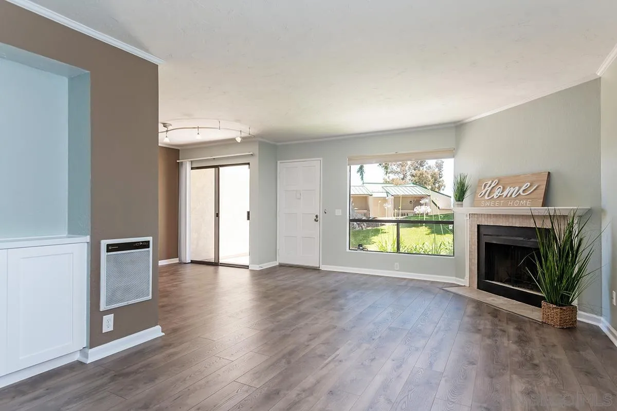 705 Copper Drive Vista, CA 92083 - Photo 8 of 31 an empty room with wooden floor fireplace and windows