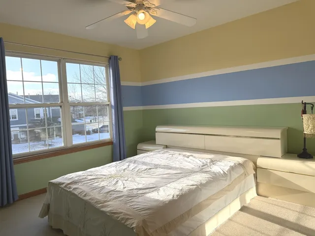 a bed sitting in a bedroom next to a window