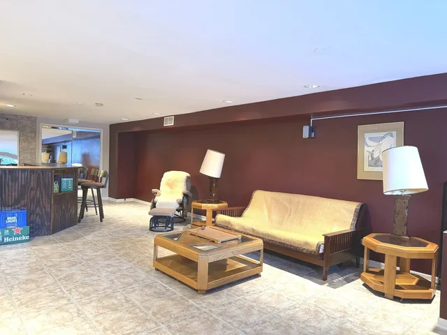 a living room with chairs and wooden floor