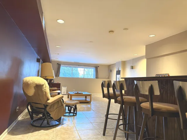 a kitchen with stainless steel appliances granite countertop a refrigerator a stove and a dining table