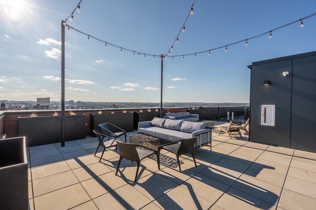 600 Broadway, Unit 509 Chelsea, MA 02150 - Photo 14 of 21 a patio with a table chairs and a barbeque