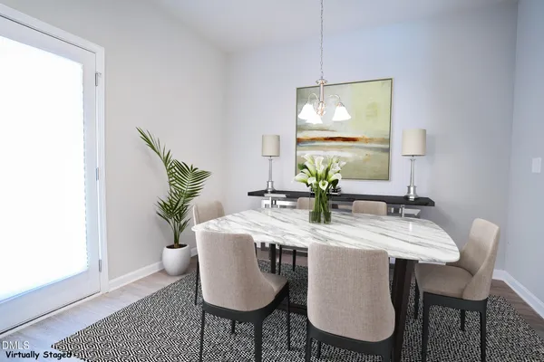 a dining room with furniture potted plants and wooden floor