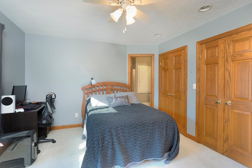966 Spring Ridge Court Belvidere, IL 61008 - Photo 24 of 44 a bedroom with a bed and a chandelier