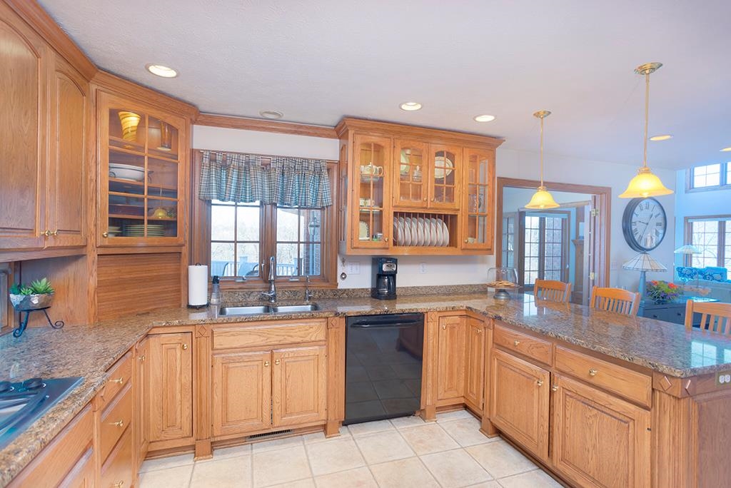 966 Spring Ridge Court Belvidere, IL 61008 - Photo 10 of 44 a large kitchen with granite countertop a sink a stove and cabinets