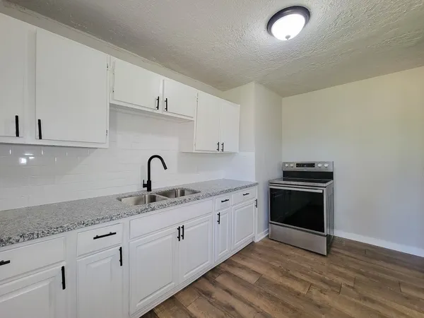 a kitchen with granite countertop a sink and cabinets