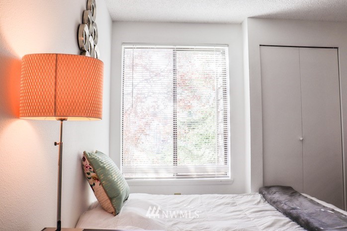 611 Southwest 5th Court, Unit A301 Renton, WA 98057 - Photo 11 of 17 a bedroom with a bed and a lamp with the window