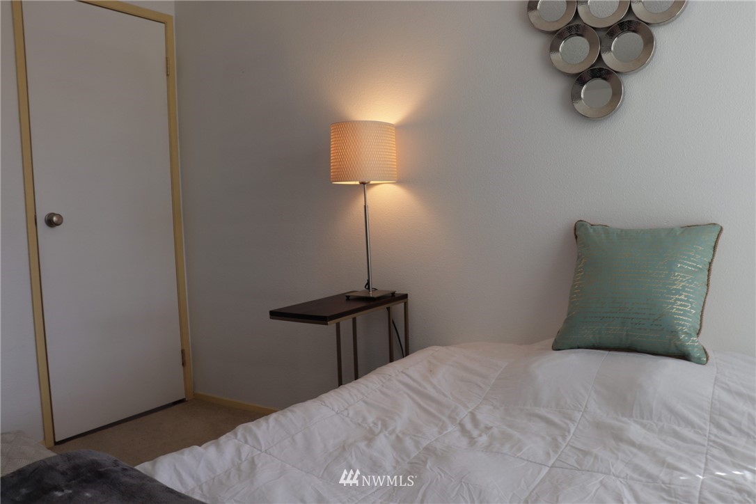 611 Southwest 5th Court, Unit A301 Renton, WA 98057 - Photo 12 of 17 a bedroom with a bed and table lamp
