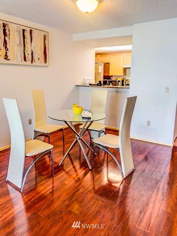 611 Southwest 5th Court, Unit A301 Renton, WA 98057 - Photo 4 of 17 a view of a dining room with furniture and wooden floor