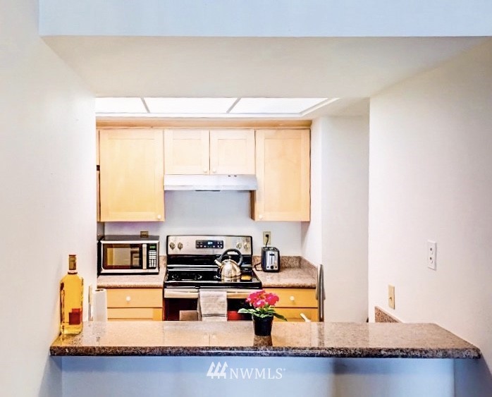611 Southwest 5th Court, Unit A301 Renton, WA 98057 - Photo 5 of 17 a kitchen with stainless steel appliances granite countertop a sink and a stove