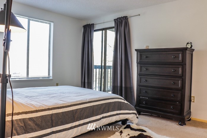 611 Southwest 5th Court, Unit A301 Renton, WA 98057 - Photo 7 of 17 a bedroom with a bed and a mirror