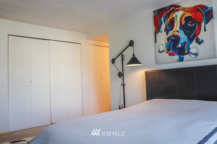 611 Southwest 5th Court, Unit A301 Renton, WA 98057 - Photo 8 of 17 a bedroom with a bed and a painting on the wall