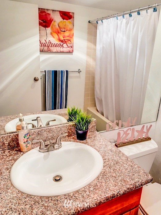611 Southwest 5th Court, Unit A301 Renton, WA 98057 - Photo 9 of 17 a bathroom with a granite countertop sink and a mirror