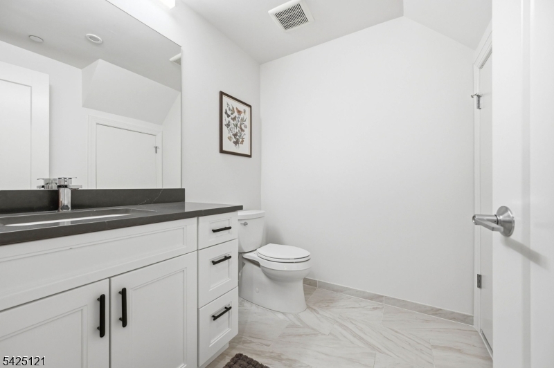 14 Ward Street Bloomfield, NJ 07003 - Photo 15 of 33 a bathroom with a granite countertop sink a toilet and a mirror
