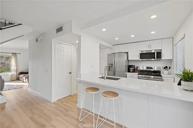 a kitchen with granite countertop a refrigerator stove microwave and sink