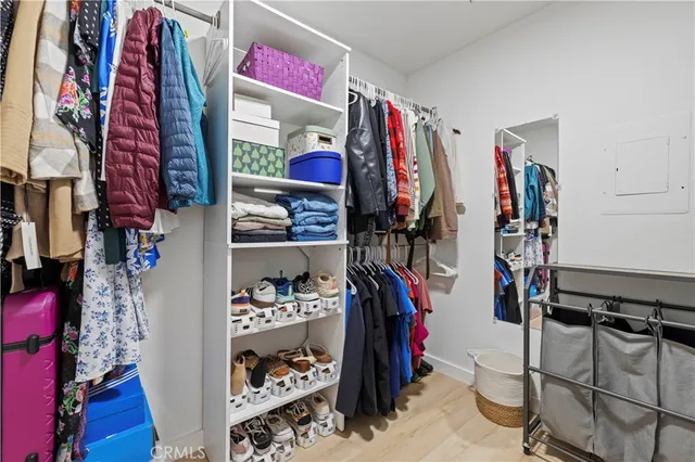 a view of walk in closet with clothes and shoes