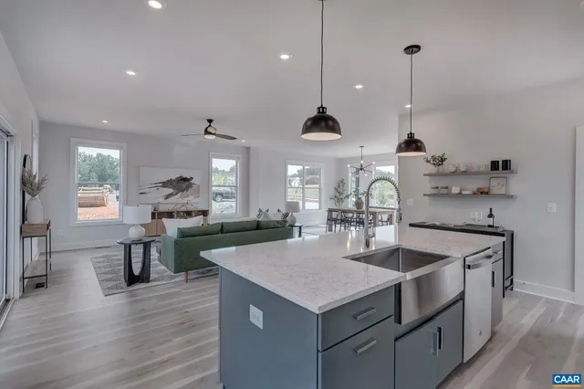 a kitchen with stainless steel appliances granite countertop a sink a stove and a wooden floors