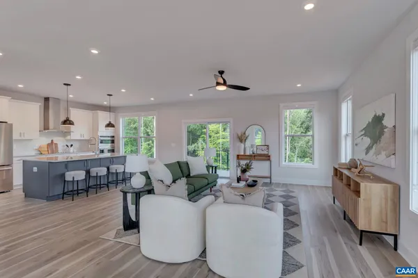 a living room with furniture dining table a large window wooden floor and a sink