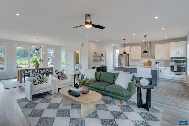 a living room with furniture and view of kitchen