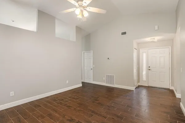 a view of an empty room with wooden floor