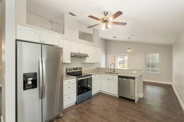 a kitchen with stainless steel appliances a stove a refrigerator sink and cabinets