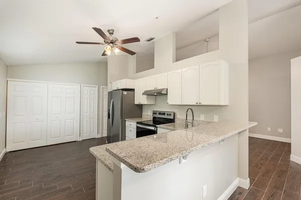 a kitchen with stainless steel appliances granite countertop a sink a stove and a refrigerator