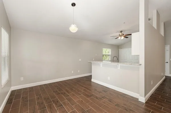 a view of a kitchen with wooden floor and electronic appliances
