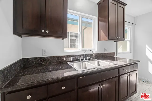 a kitchen with granite countertop a stove and a sink