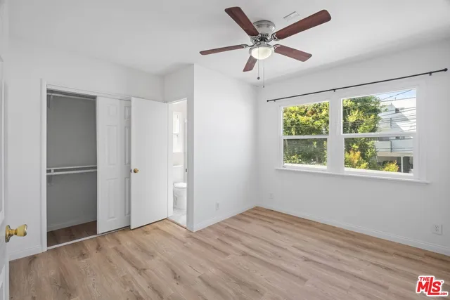 an empty room with wooden floor a ceiling fan and closet