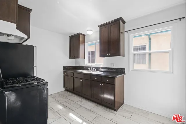 a kitchen with stainless steel appliances granite countertop a stove a refrigerator and a cabinets