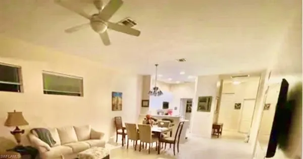 a view of a white house with a tree in the background