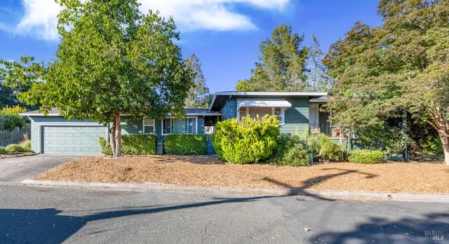 a front view of a house with a yard and potted plants