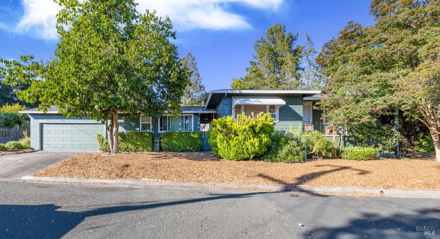a front view of a house with a yard and potted plants