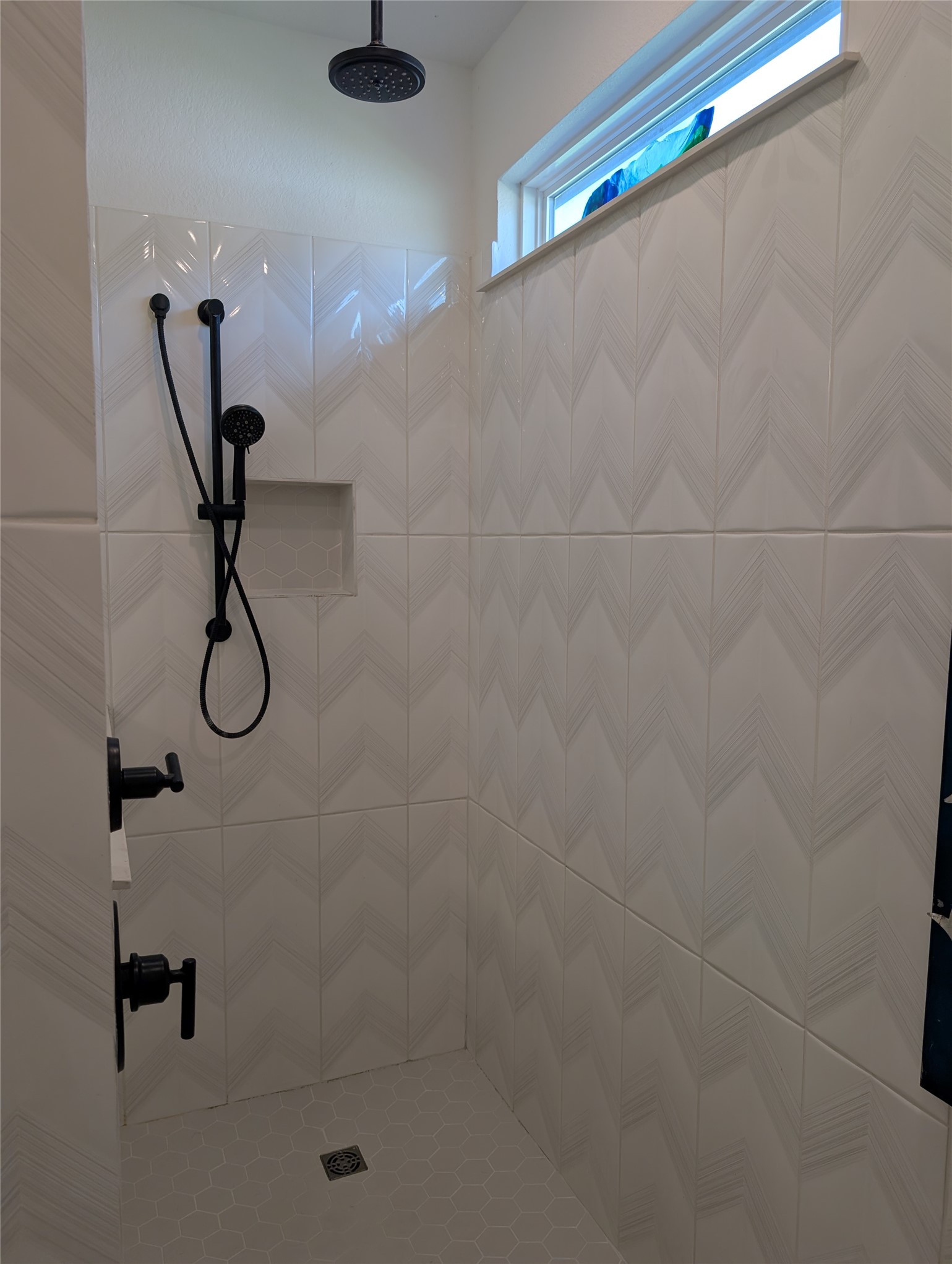 336 Kitty Hawk Road Georgetown, TX 78633 - Photo 24 of 40 Chevron wall tiles and a rainfall showerhead elevate this modern walk-in shower design.