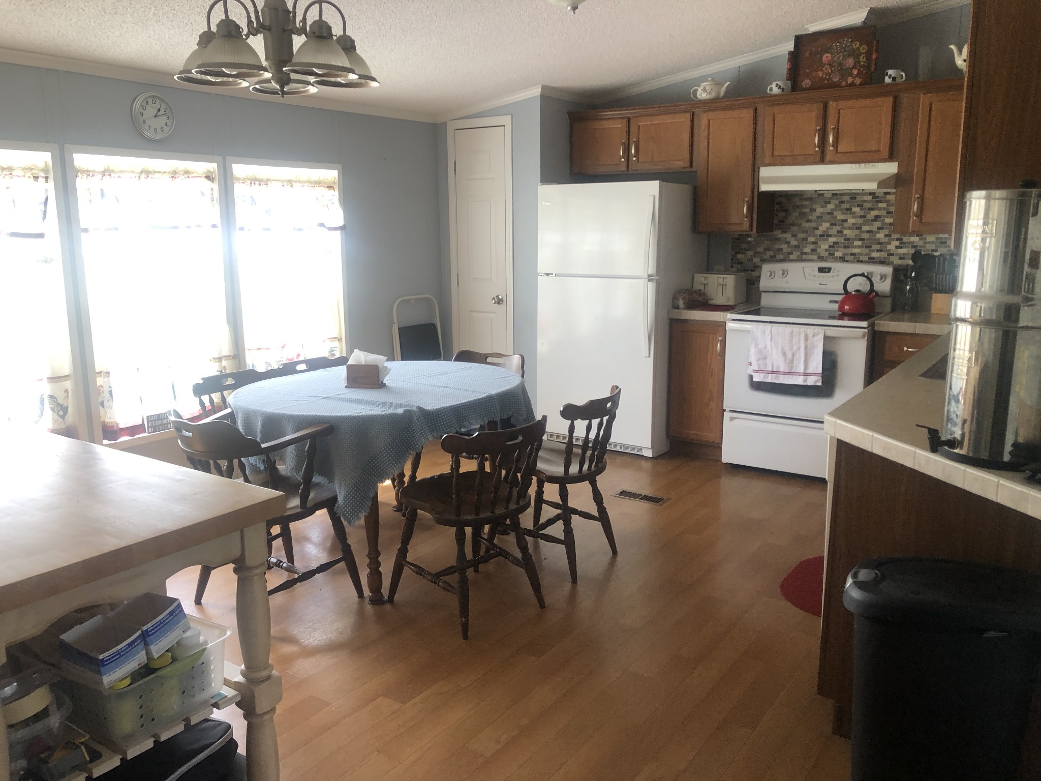 8063 Galen Road Lafayette, TN 37083 - Photo 11 of 18 a kitchen with stainless steel appliances granite countertop a stove a refrigerator a microwave a dining table and chairs with wooden floor