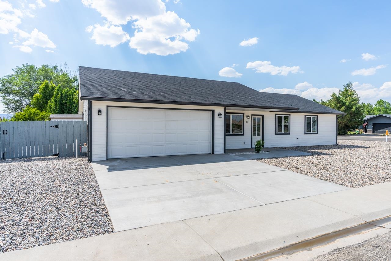 411 Cedar Glen Way Fruita, CO 81521 - Photo 1 of 25 a front view of a house with a yard and garage