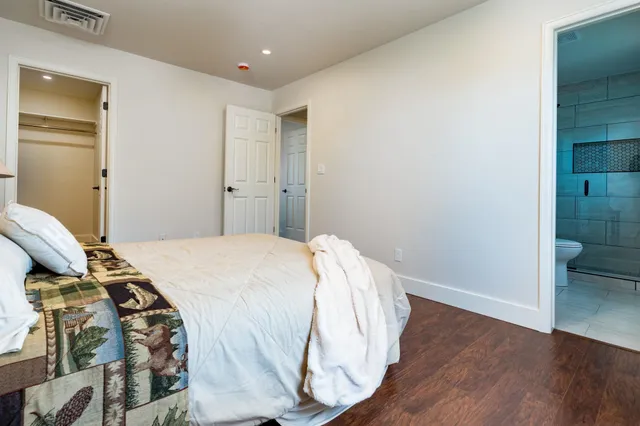 a bedroom with a bed and wooden floor