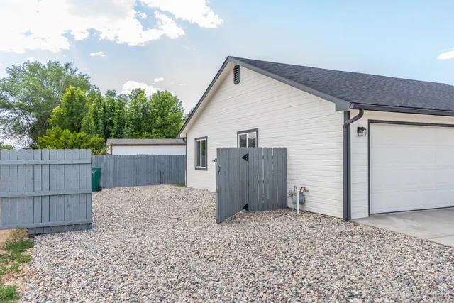 a view of backyard of house with wooden fence