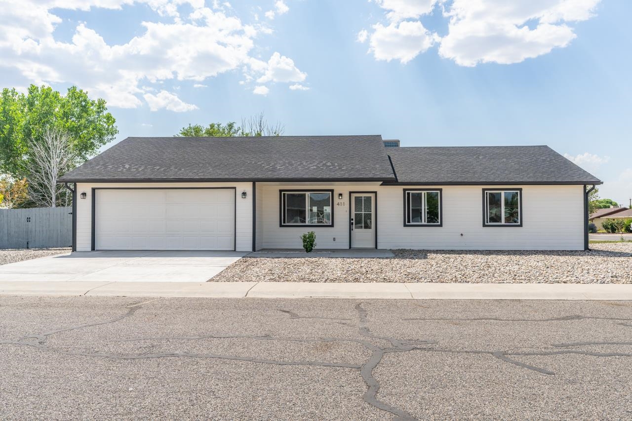 411 Cedar Glen Way Fruita, CO 81521 - Photo 2 of 25 a front view of a house with a garden and trees